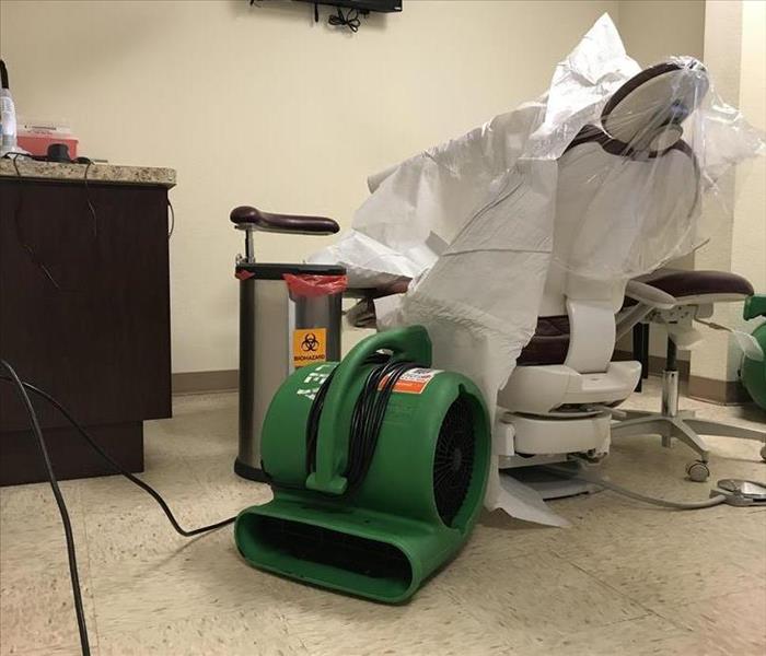 Commercial air dryers set up on the floor of a dental examining room. 